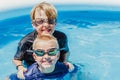 Two boys swimming in a small pool in summer Royalty Free Stock Photo