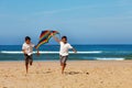 Two boys brothers run on the beach with kite Royalty Free Stock Photo