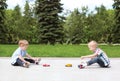 Two boys children playing together with toys outdoors
