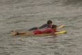 Two boys come into the sea to surf Royalty Free Stock Photo