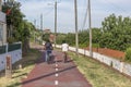 Two boys cycling on pedestrian cycle path, with street lamps, blue sky as background and vegetation, in Viseu, Portugal Royalty Free Stock Photo