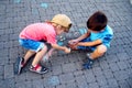 Two boys draw with chalk on the pavement. The concept of a happy childhood