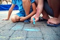 Two boys draw with chalk on the pavement. The concept of a happy childhood.