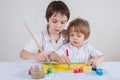 Two boys draw together. Everyone draws on their own half of the paper Royalty Free Stock Photo