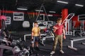 Two boys are engaged in the gym with dumbbells and weights