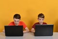 Two boys are engaged online on laptops, network games. Online learning at home concept. Children play computer games Royalty Free Stock Photo