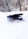 Two boys fall from a tubing on a snow slide