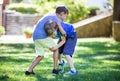 Two boys fighting outdoors. Siblings or friends wrestling on grass in summer park Royalty Free Stock Photo