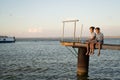 Two boys fishing with a fishing rod on a lake at sunset. Children& x27;s summer vacation Royalty Free Stock Photo