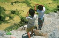 Two boys fishing at a pond