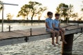 Two boys is fishing at sunset on the lake. Kids are playing on nature. Royalty Free Stock Photo
