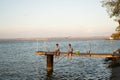 Two boys fishing at sunset on the lake, water background Royalty Free Stock Photo