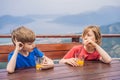 Two boys friend drink juice, enjoys the view of Kotor. Montenegro. Bay of Kotor, Gulf of Kotor, Boka Kotorska and walled