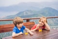Two boys friend drink juice, enjoys the view of Kotor. Montenegro. Bay of Kotor, Gulf of Kotor, Boka Kotorska and walled