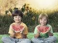 Two boys with fruit in park. Happy child eating watermelon in the garden Royalty Free Stock Photo