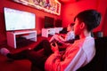 Two boys gamers play football gamepad video game console in red gaming room Royalty Free Stock Photo