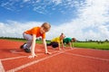 Two boys and girl on bended knee ready to run