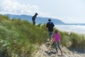 Two boys and a girl explore sand dunes on beach Royalty Free Stock Photo