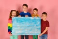 Two boys and a girl are holding a blank poster for inscription and text Royalty Free Stock Photo