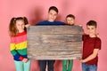 Two boys and a girl are holding a blank poster for inscription and text