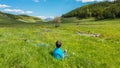 Two boys in the grass by a mountain stream