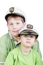 Two boys in green T-shirts and white sea peak-caps Royalty Free Stock Photo