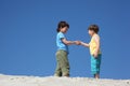Two boys greet on sand Royalty Free Stock Photo