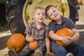 Two Boys Having Fun at the Pumpkin Patch on a Fall Day