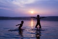 Two boys jumping into water on sunset Royalty Free Stock Photo