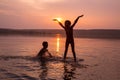Two boys jumping into water on sunset Royalty Free Stock Photo