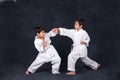 Two boys of the karate in a white kimono battle