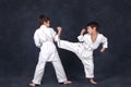 Two boys of the karate in a white kimono battle