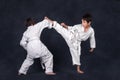 Two boys of the karateka in a white kimono battle