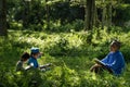 Two boys study with their grandfathers in the open nature.