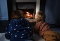 Two boys lay in front of the home fireplace look at fire Royalty Free Stock Photo