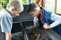 Two boys light fire on grill in gazebo Royalty Free Stock Photo