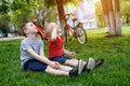 Two boys look up sitting on the grass. Bicycles in the background Royalty Free Stock Photo