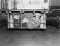 Two boys with milk canisters in a cargo bay of a truck