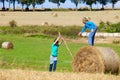 Two Boys Moving Bale of Hay