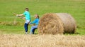 Boys Moving Bale of Hay with Stick as a Lever