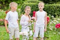 Two boys and one girl stand on lawn planted with