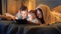 Two boys in pajamas having fun with mother in bed and playing games on tablet computer. Family having time together, parenting, Royalty Free Stock Photo