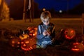 Two boys in the park with Halloween costumes, carved pumpkins with candles and decoration Royalty Free Stock Photo
