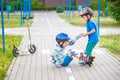 Two boys in park, help boy with roller skates to stand up Royalty Free Stock Photo