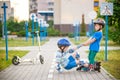 Two boys in park, help boy with roller skates to stand up Royalty Free Stock Photo