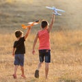 Two boys play outdoors launching toy planes, summer concept Royalty Free Stock Photo