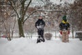 Two boys play on a pile of snow after heavy snowfall in the city. Children on a walk in the park in winter. Active healthy Royalty Free Stock Photo