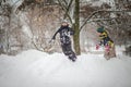 Two boys play on a pile of snow after heavy snowfall in the city. Children on a walk in the park in winter. Active healthy Royalty Free Stock Photo