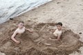 Two boys play on sandy beach of Lake Seliger Royalty Free Stock Photo