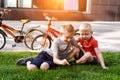 Two boys play sitting on the grass. Rest after cycling, Bicycles in the background Royalty Free Stock Photo